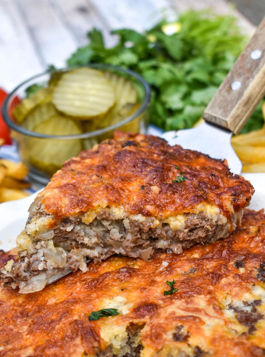 a wooden spatula holding up a slice of grandma's easy cheeseburger pie