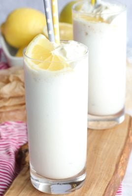 two tall slender glasses filled with copy cat chick fil a frosted lemonade and shown on a small wooden cutting board