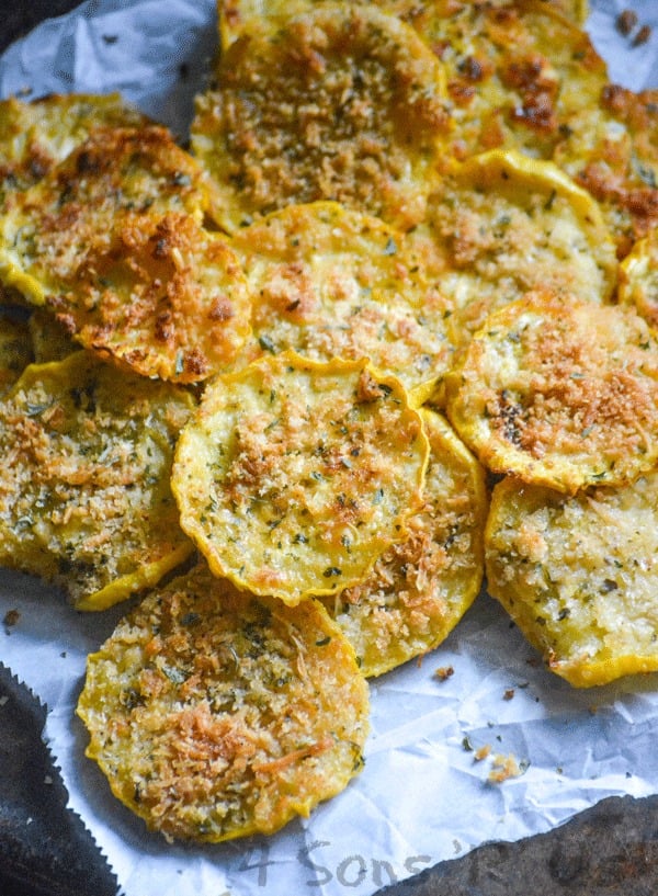 Crispy Garlic Parmesan Squash Chips piled on white parchment paper