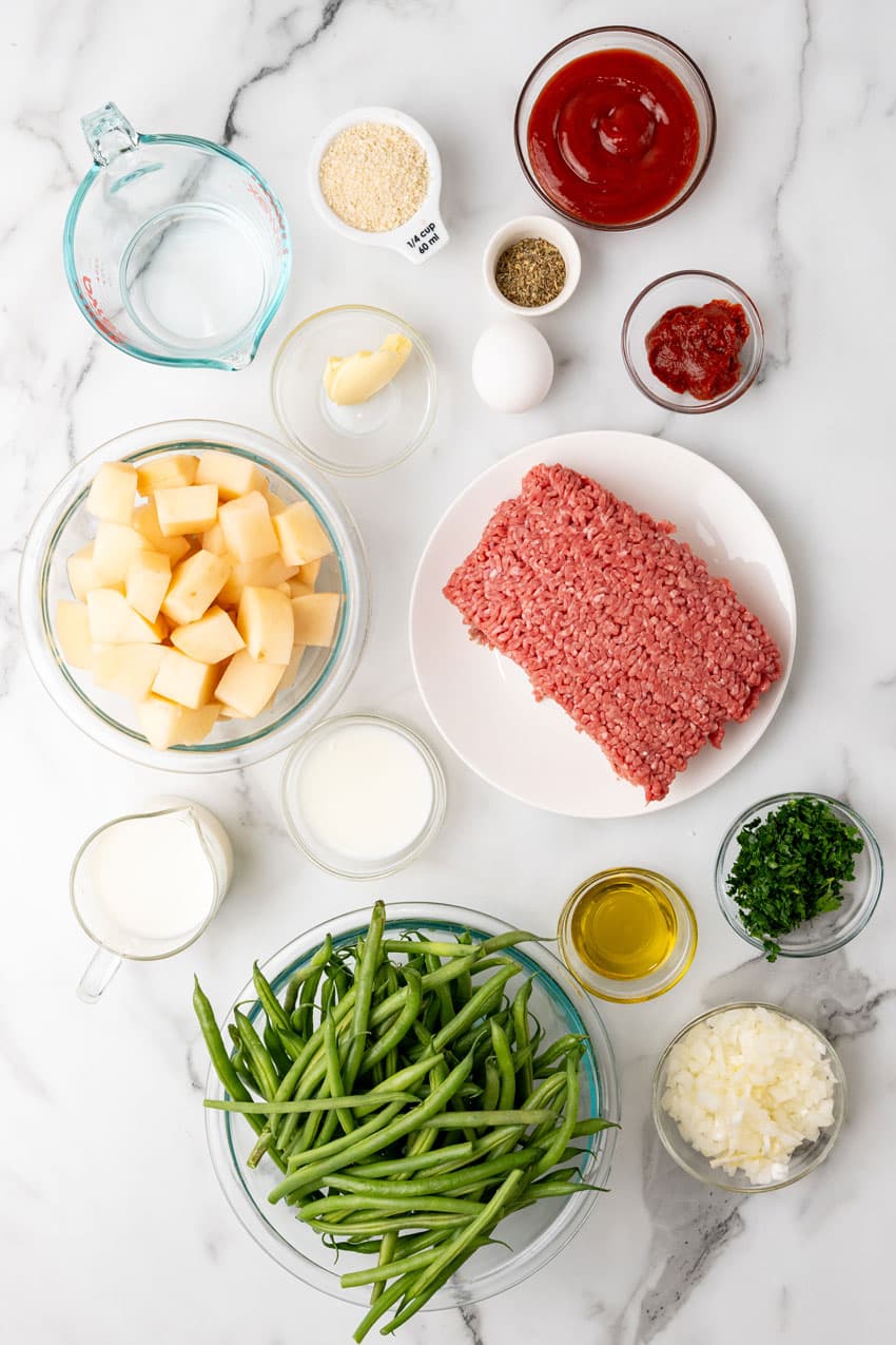 an overhead image showing the measured ingredients needed to make a sheet pan meatloaf dinner