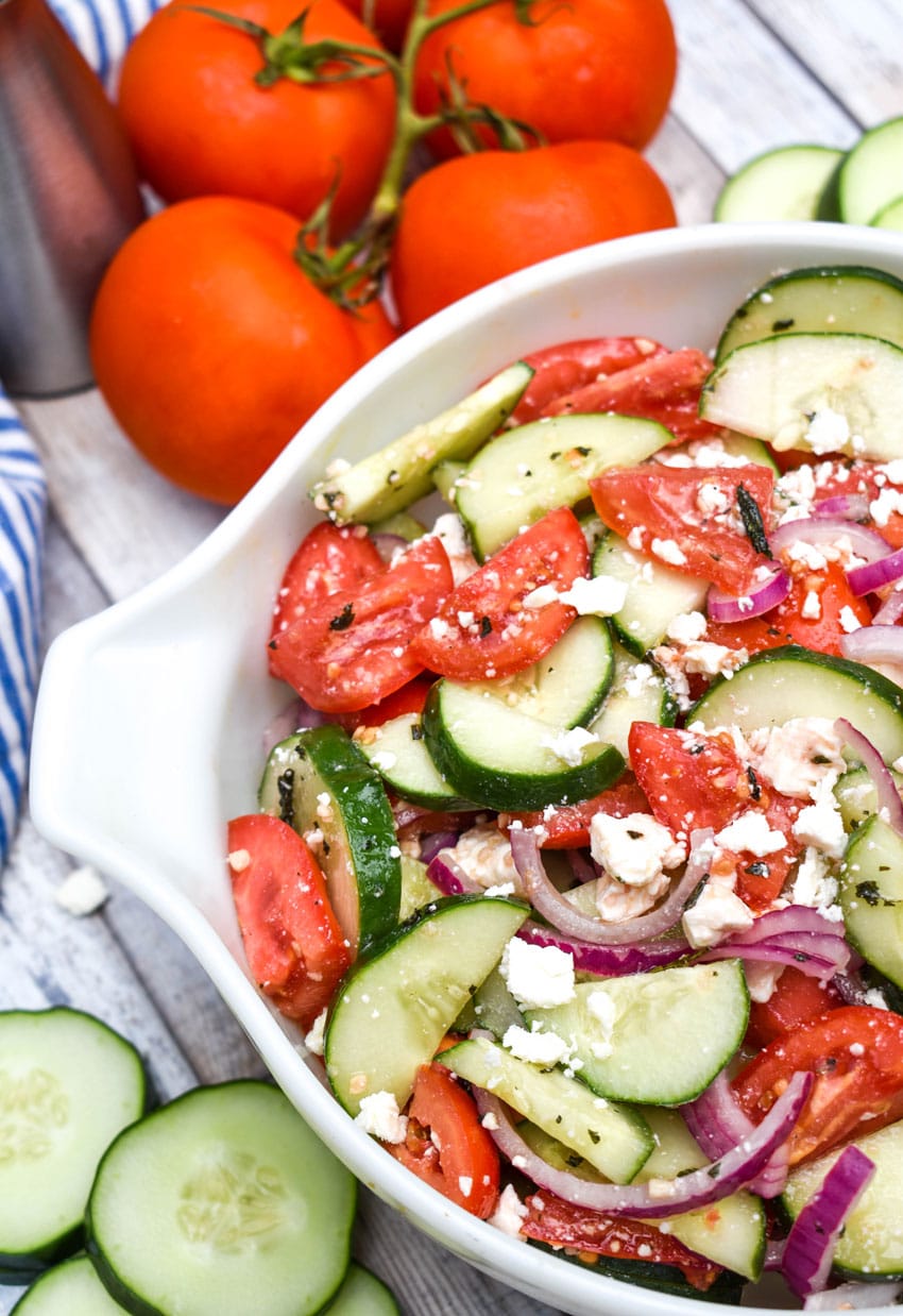 tomato cucumber feta salad in a large white serving bowl