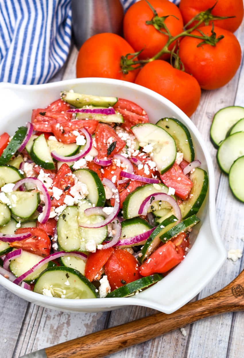 tomato cucumber feta salad in a large white serving bowl