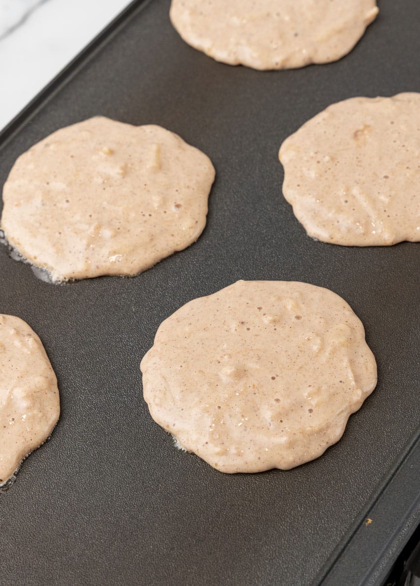apple pie pancakes cooking on a countertop griddle