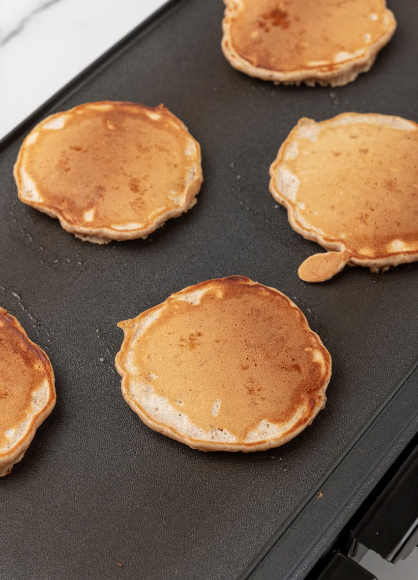 cooked apple pie pancakes on a countertop griddle