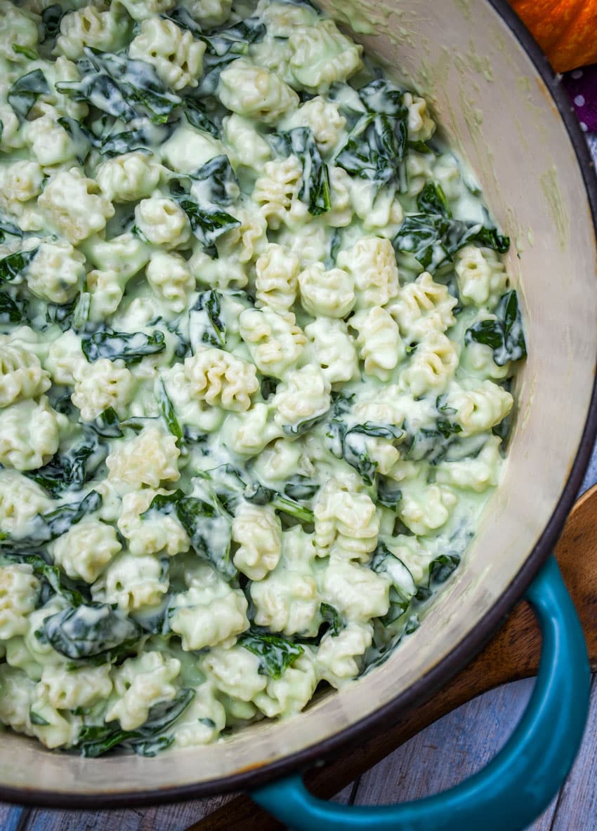 white cheddar mac and cheese with spinach in a large cast iron pot