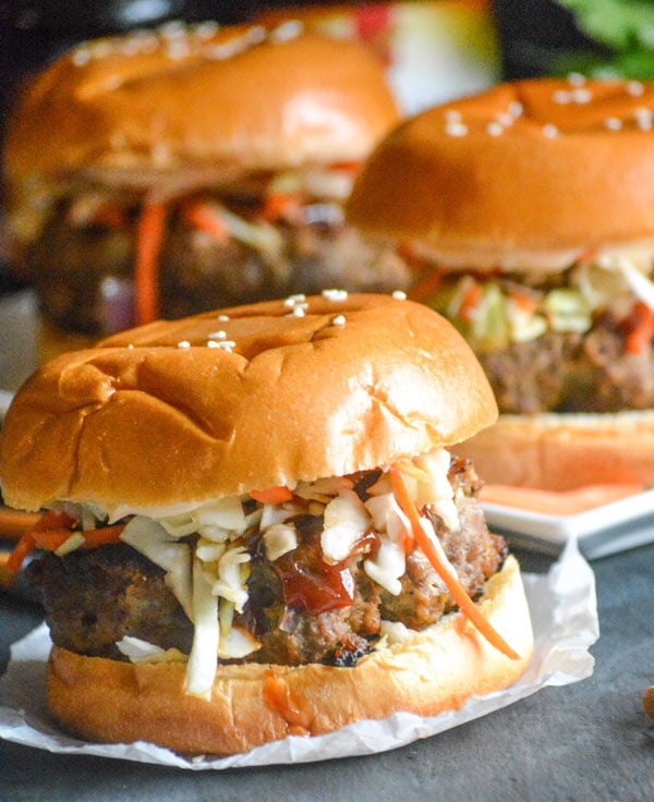 mongolian barbecue burgers with asian slaw on sheets or parchment paper