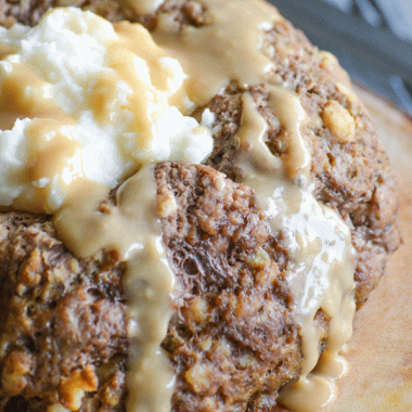 stovetop stuffing mix meatloaf with mashed potatoes in the center and drizzled with gravy on a wooden cutting board