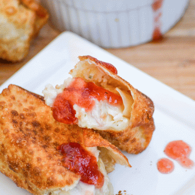 thanksgiving leftover egg rolls dripping with cranberry dipping sauce on a white appetizer plate