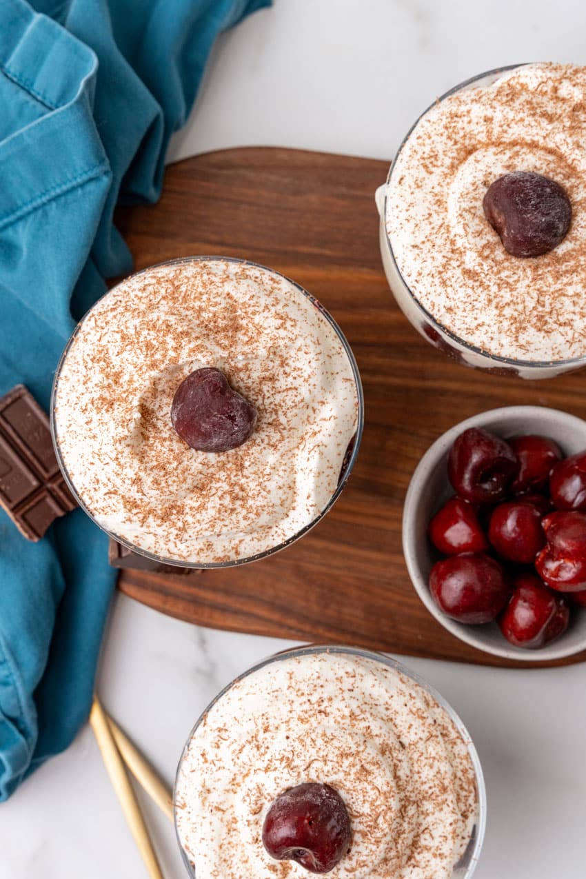 black forest cherry cheesecake cups on a wooden cutting board