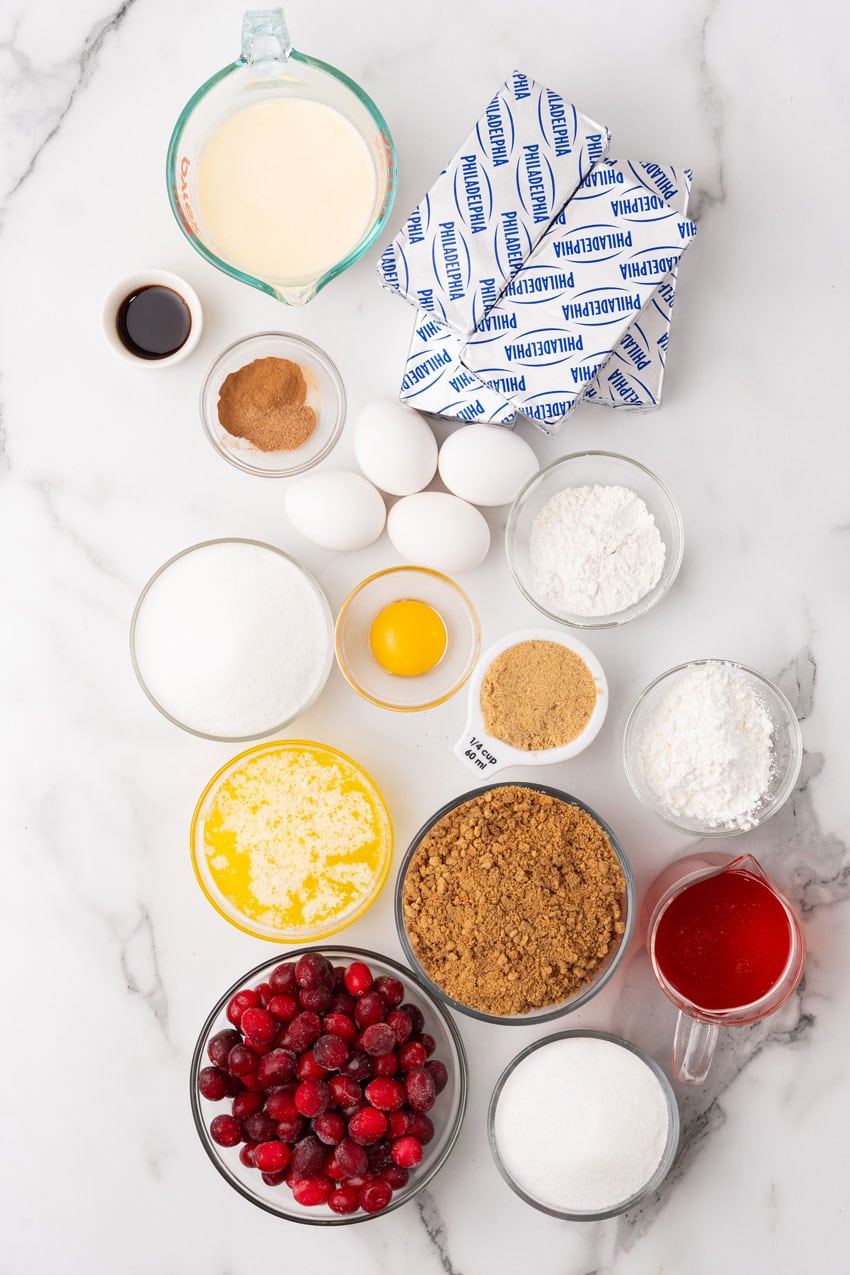 an overhead image showing the measured ingredients needed to make an eggnog cheesecake with cranberry topping