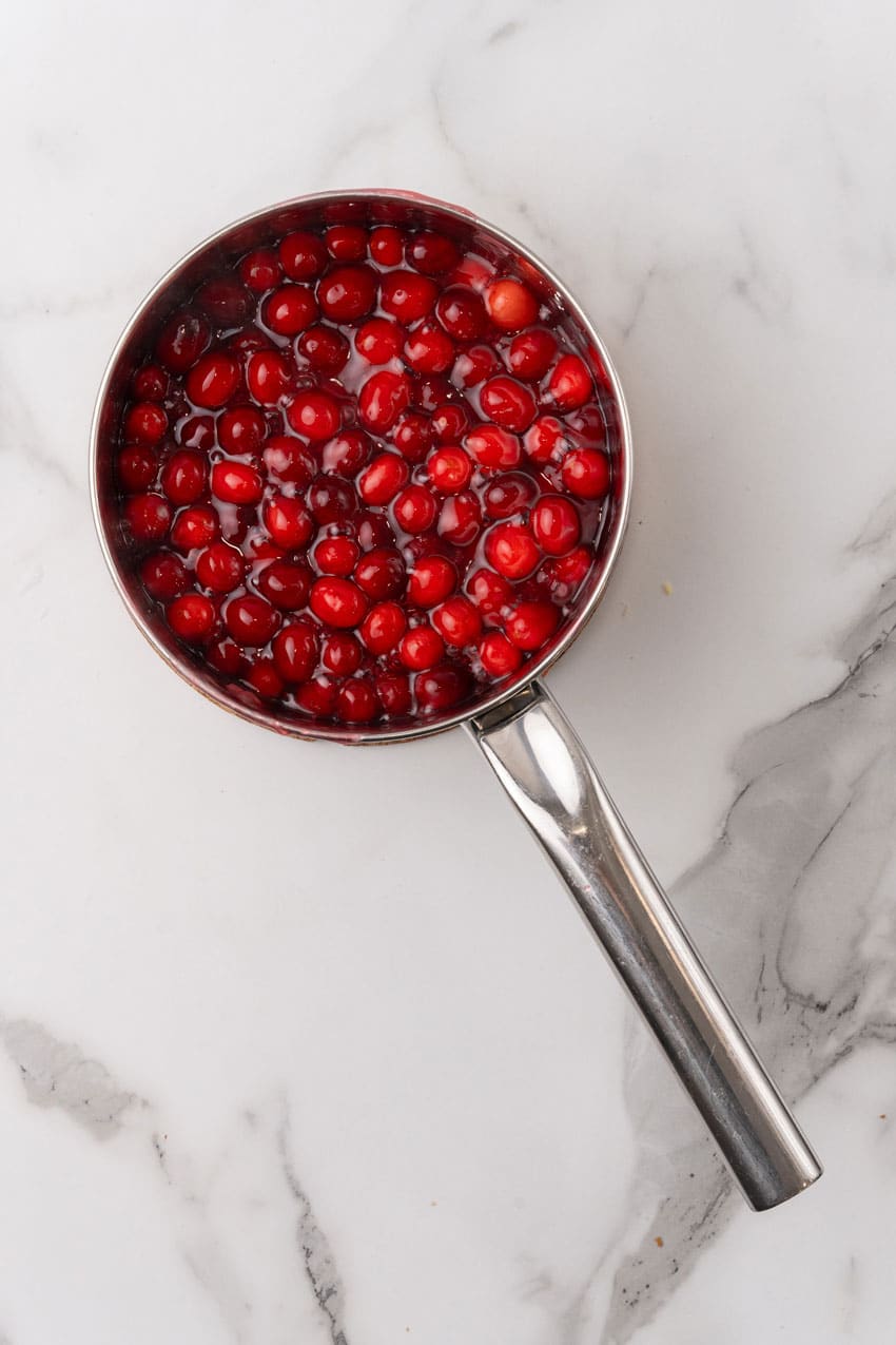 boiled cranberries in syrup in a small pot