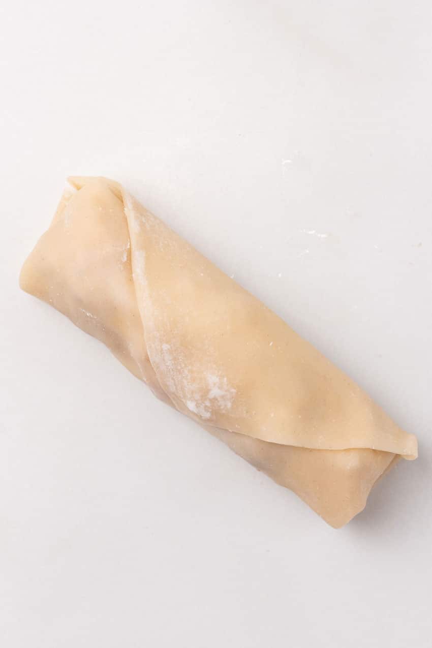 a finished folded homemade egg rolls on a white counter