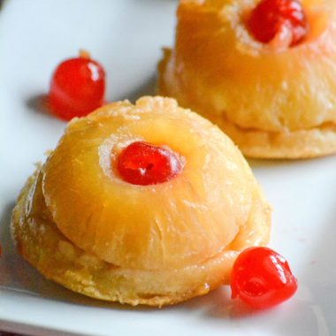 PINEAPPLE UPSIDE DOWN COOKIE CAKES ON A WHITE SERVING PLATTER WITH MARASCHINO CHERRIES ON THE SIDE