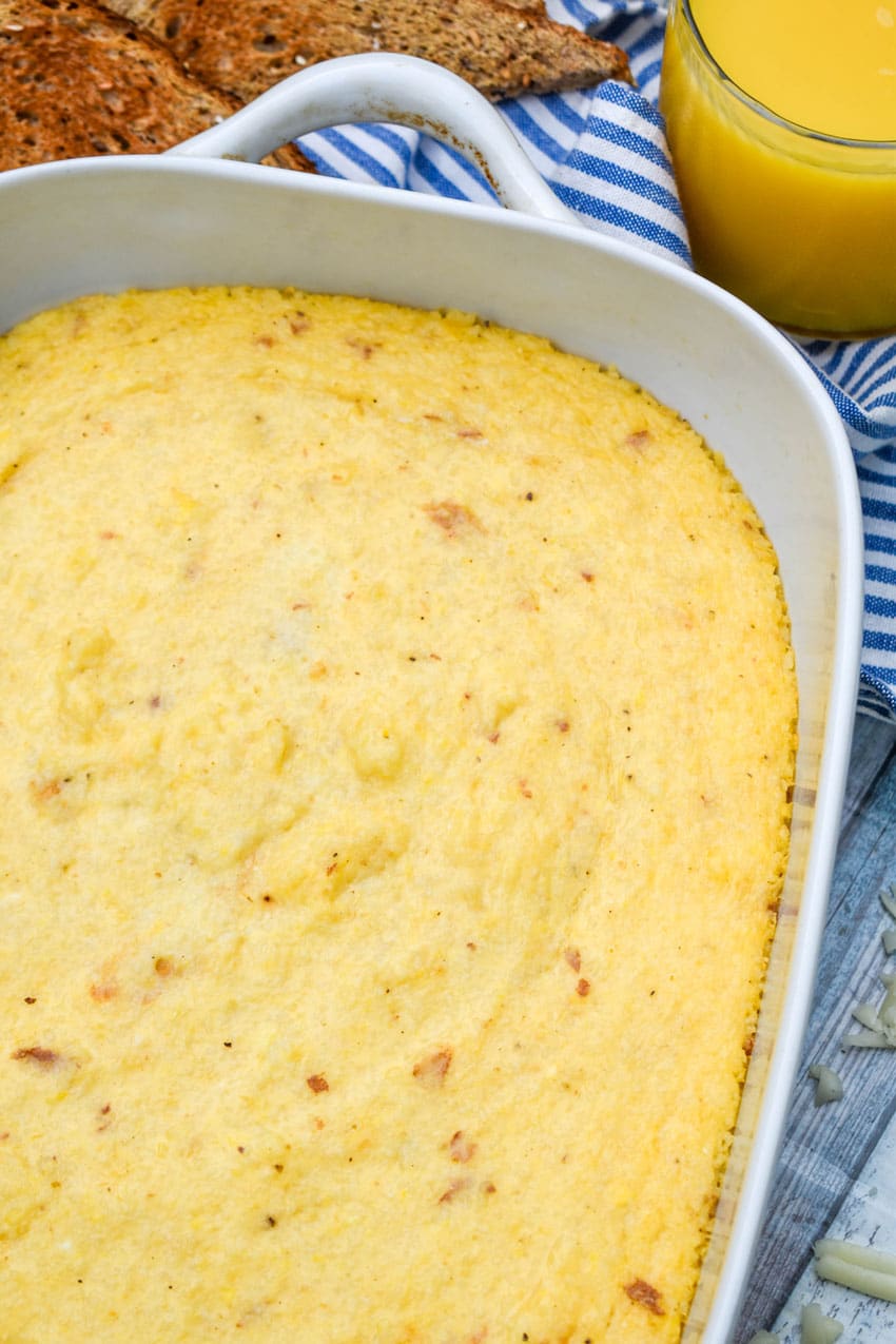 three cheese grits casserole in a white baking dish