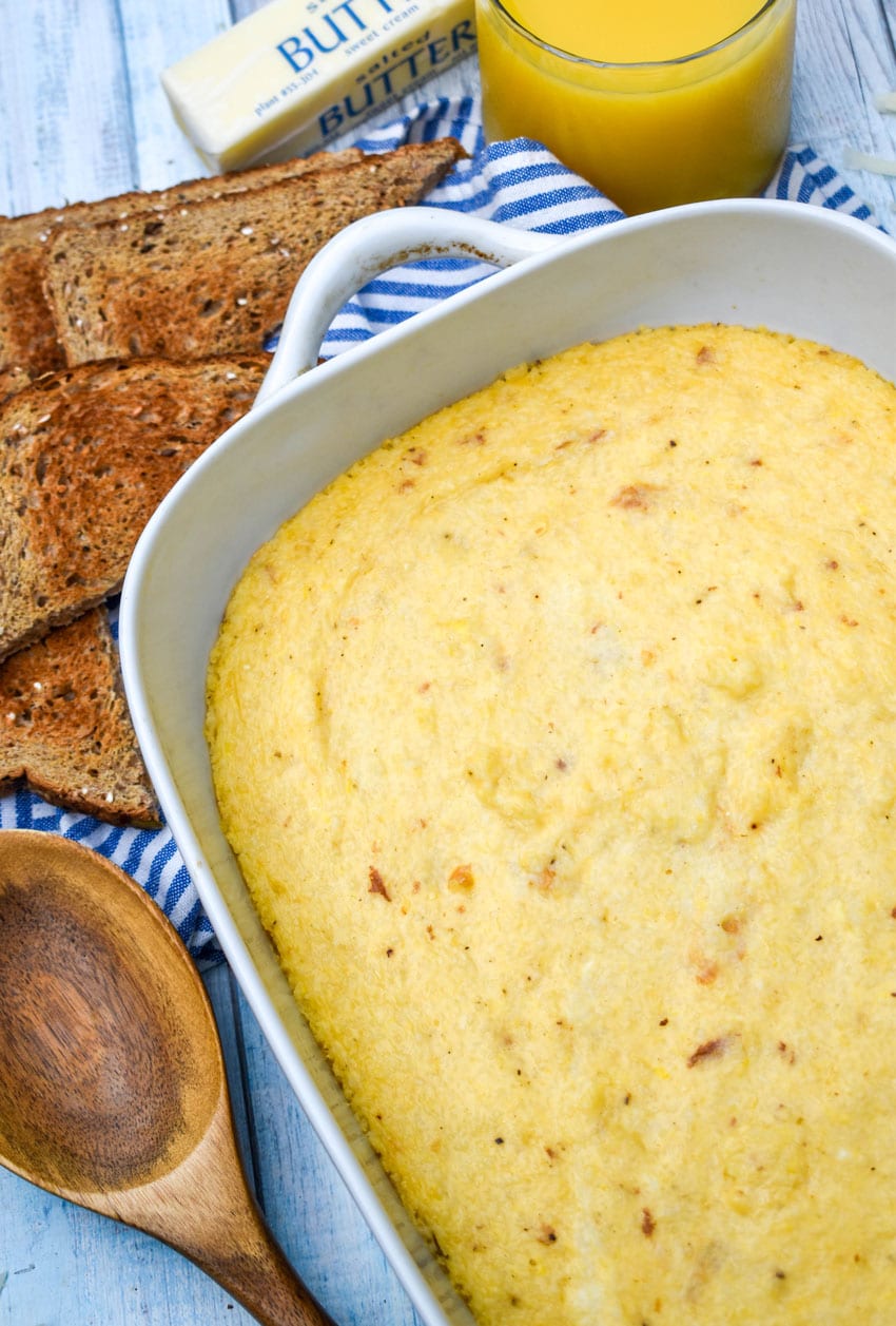 three cheese grits casserole in a white baking dish