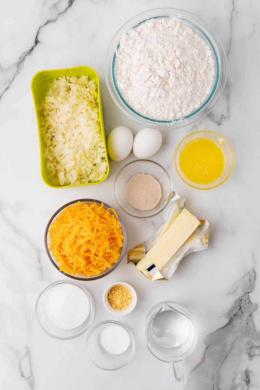 an overhead image showing the measured ingredients needed to make a batch of cheesy pull apart potato rolls