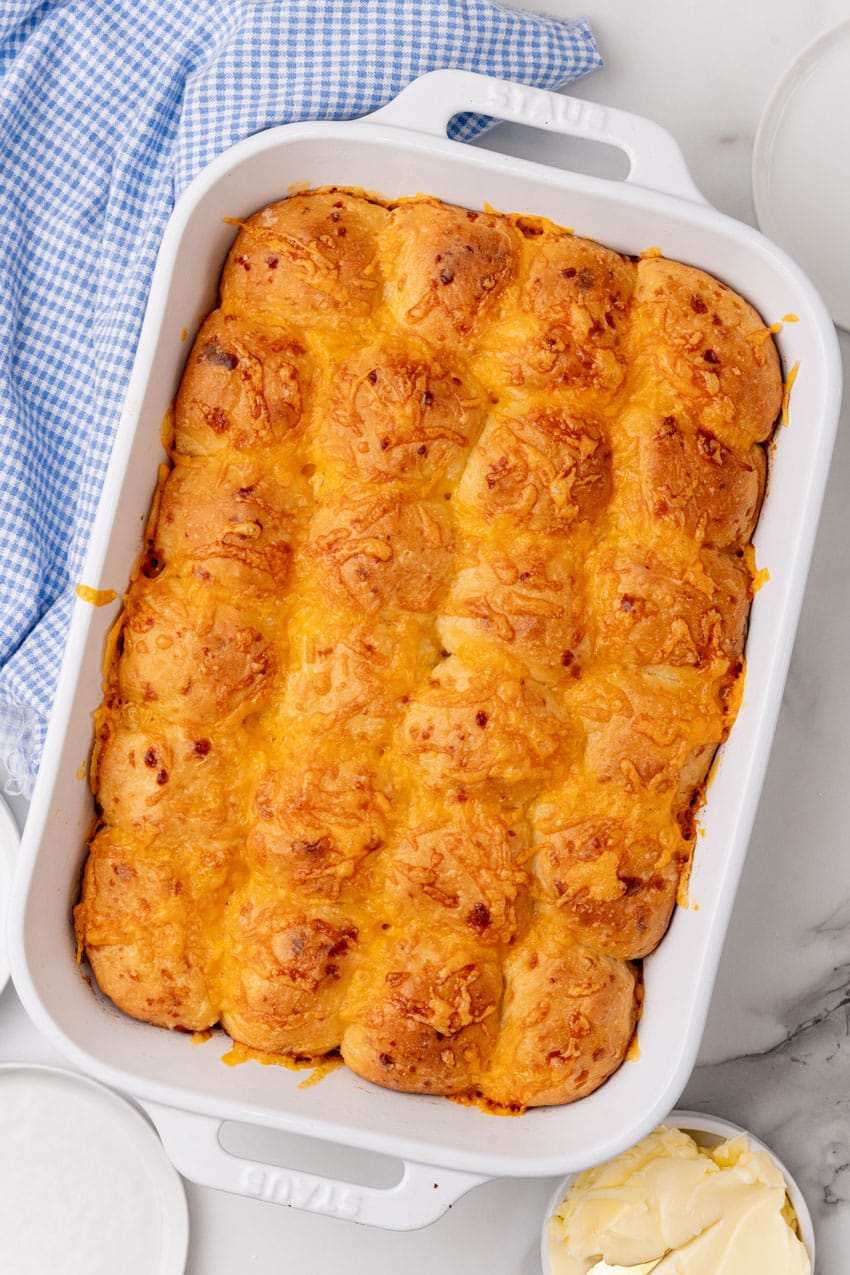 cheesy baked pull apart potato rolls in a white casserole dish