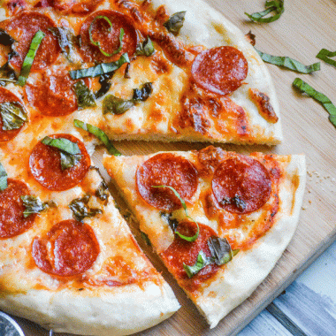 a slice cast iron pizza on a wooden cutting board