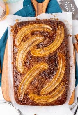 bananas foster upside down cake on a parchment paper lined wooden cutting board