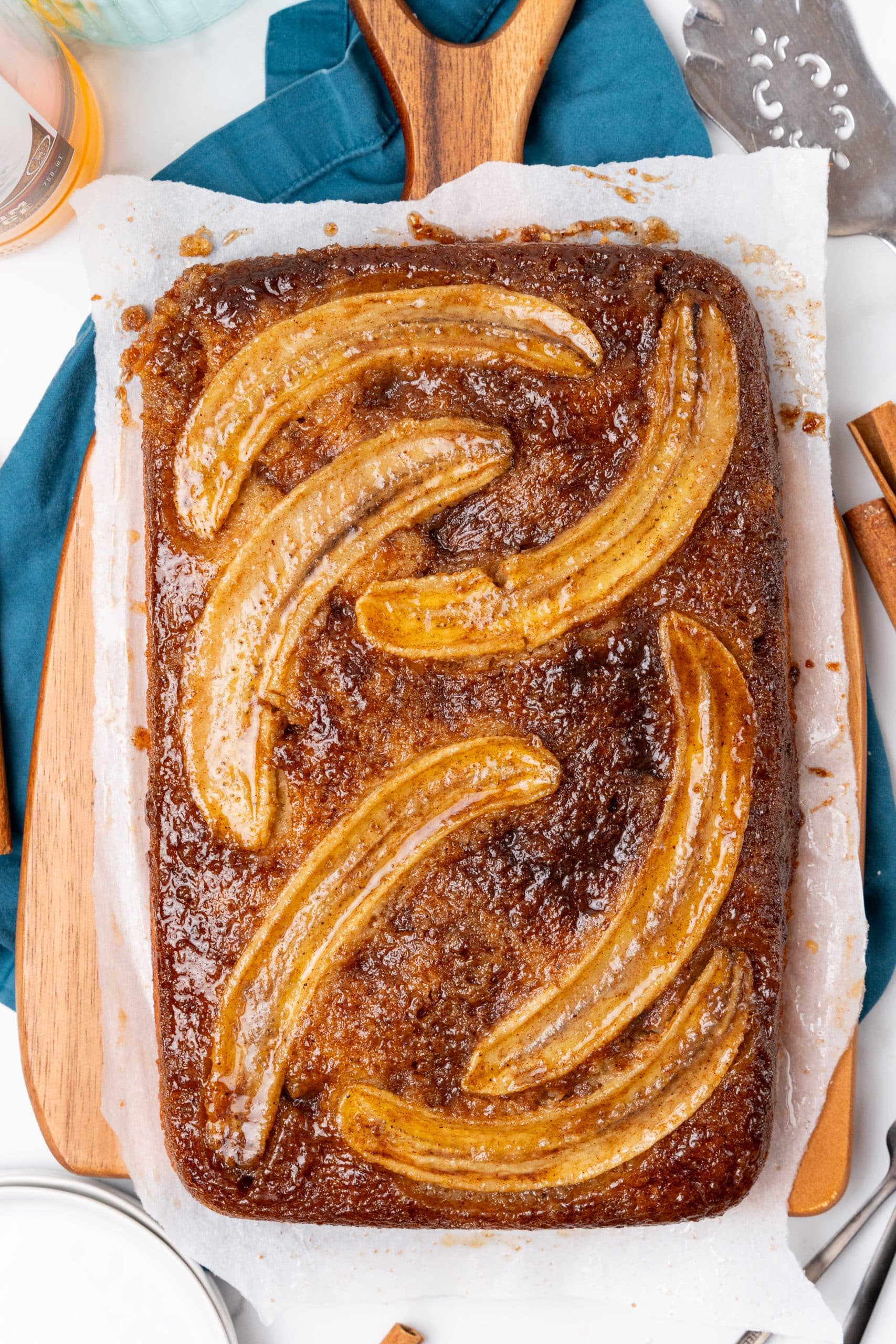 bananas foster upside down cake on a parchment paper lined wooden cutting board
