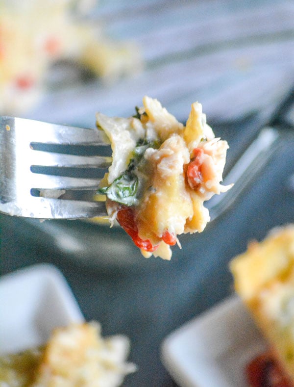 a bite of Chicken Caesar Lasagna shown on the end of a fork in close up view