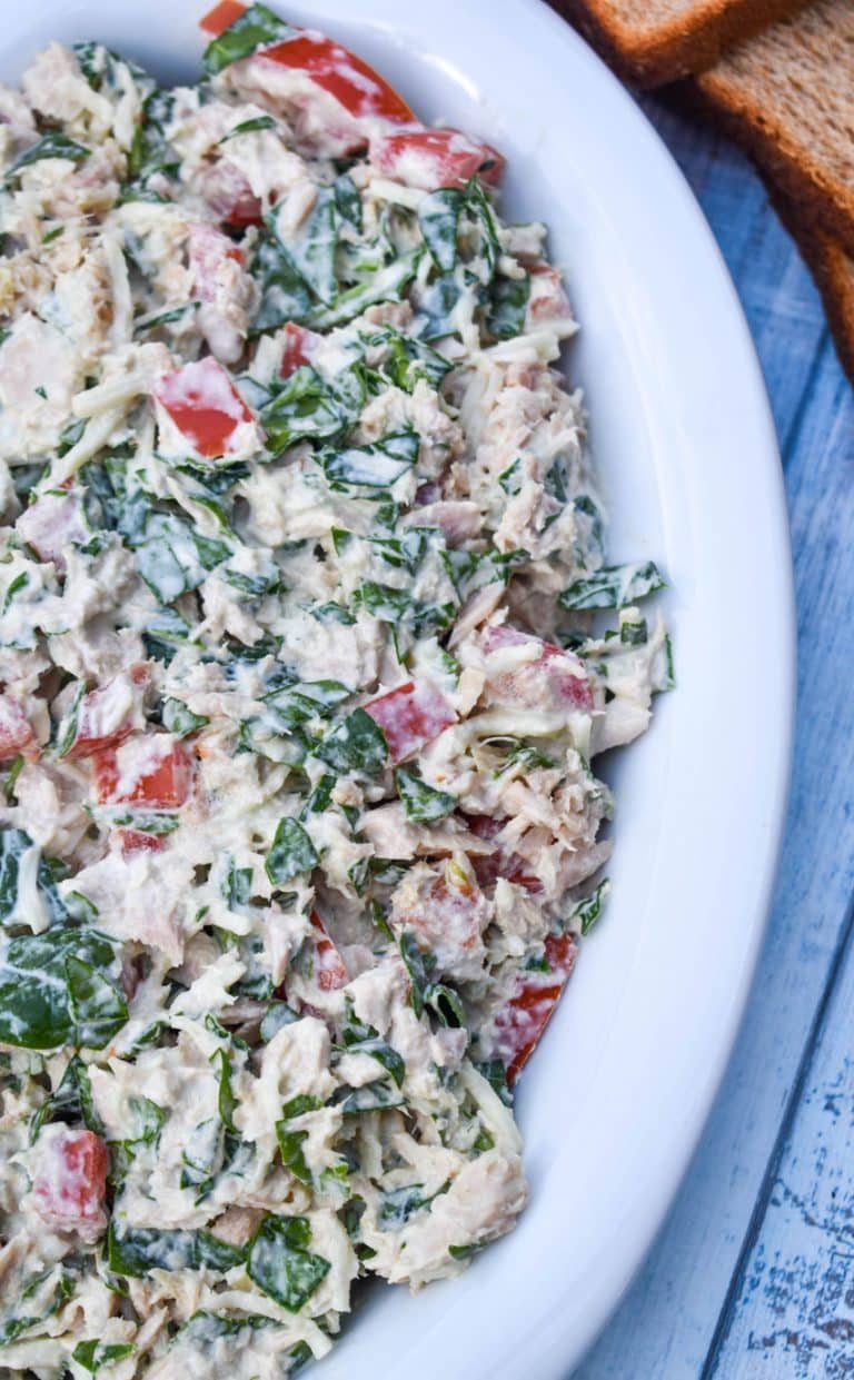 spinach and tomato tuna salad with greek yogurt in a white serving bowl