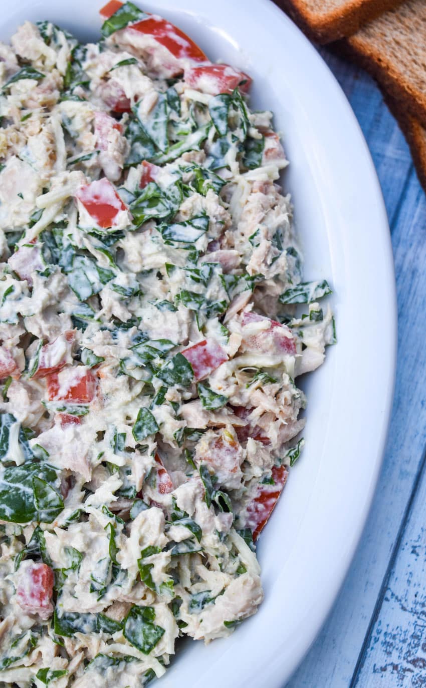 spinach and tomato tuna salad with greek yogurt in a white serving bowl
