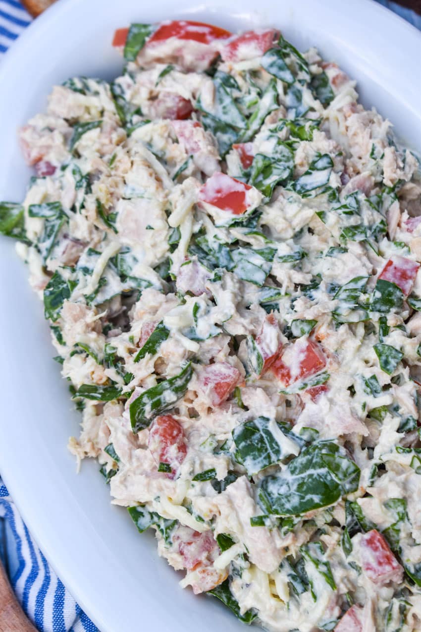 spinach and tomato tuna salad with greek yogurt in a white serving bowl