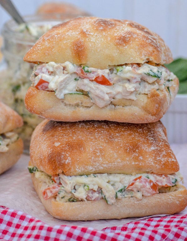 two Spinach & Tomato Tuna Salad Sandwiches stacked on top of each other 