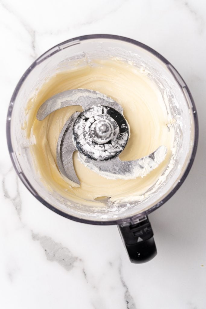 cream cheese frosting in the bowl of a food processor