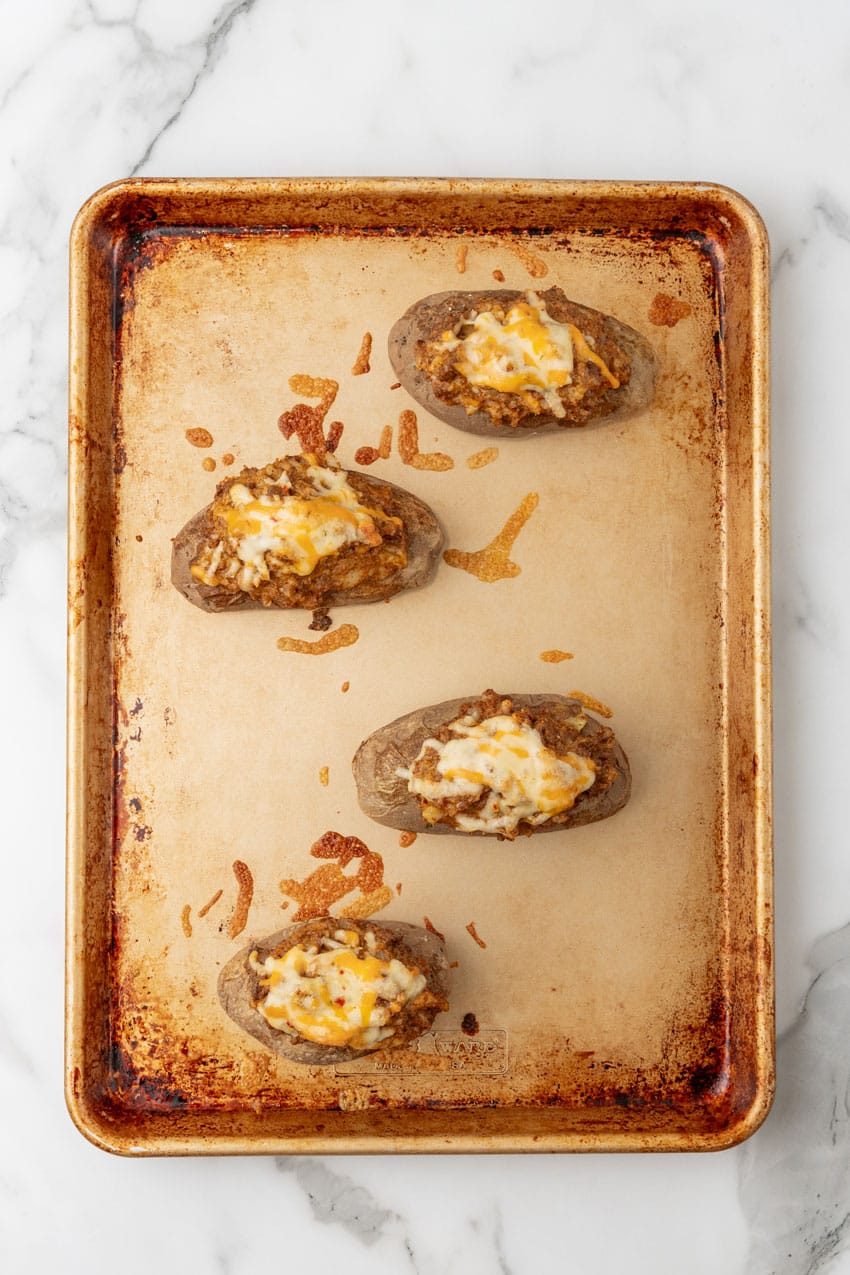 twice baked taco baked potatoes on a metal baking tray