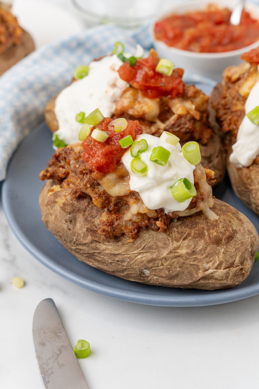 twice baked taco baked potatoes on a blue dinner plate