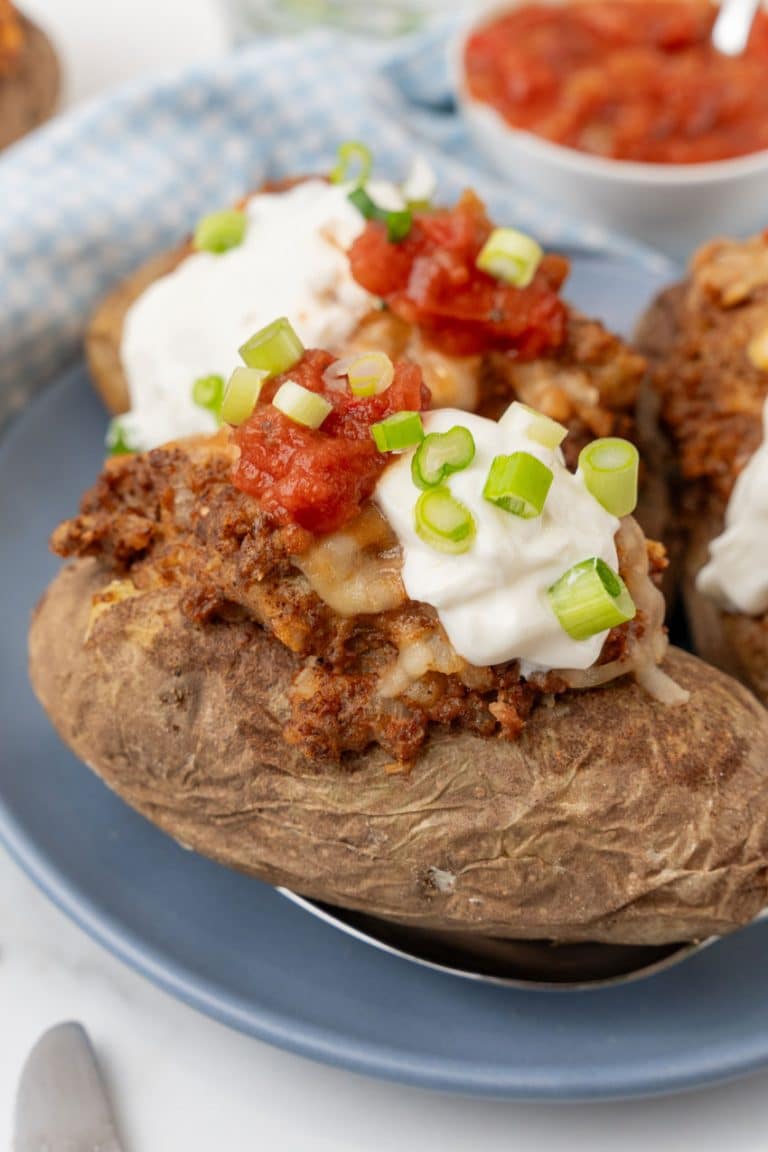 twice baked taco baked potatoes on a blue dinner plate