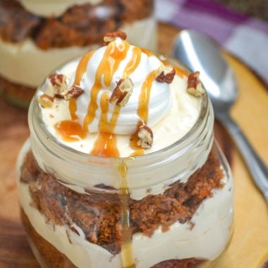 CARROT CAKE PUDDING TRIFLES IN MASON JARS ON A WOODEN CUTTING BOARD