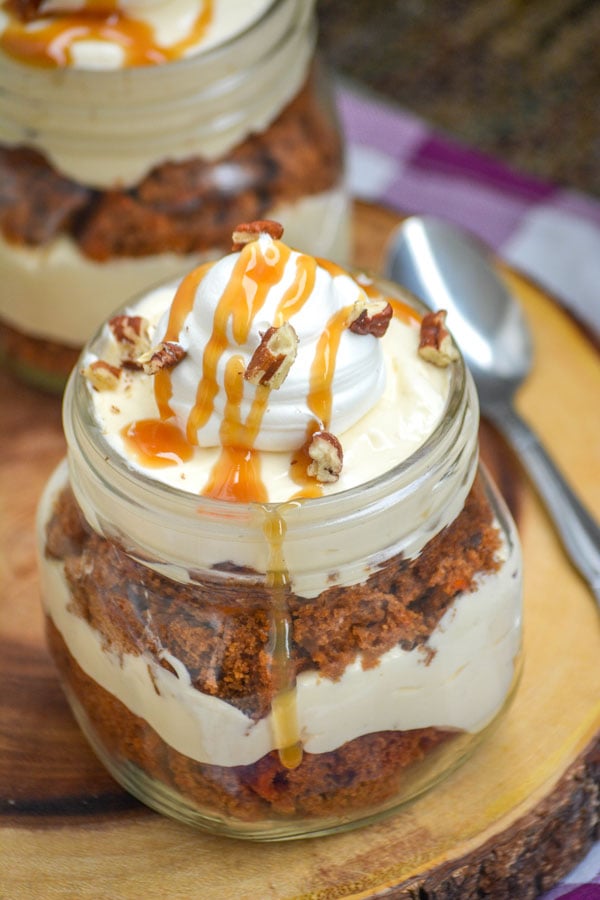 CARROT CAKE PUDDING TRIFLES IN MASON JARS ON A WOODEN CUTTING BOARD