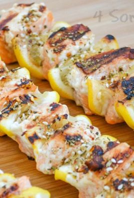 grilled lemon herb salmon kebabs on a wooden cutting board