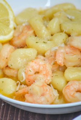 shrimp scampi gnocchi served in a white bowl with a lemon slice on the side