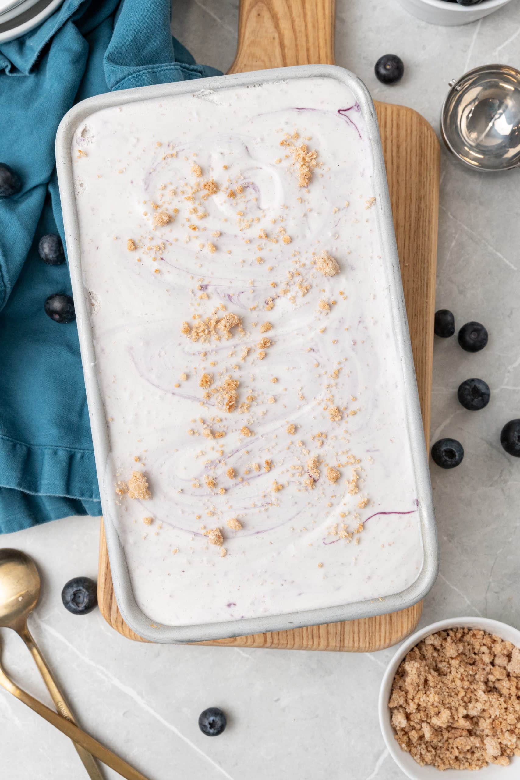 no churn blueberry muffin ice cream in a metal baking tin on a wooden cutting board