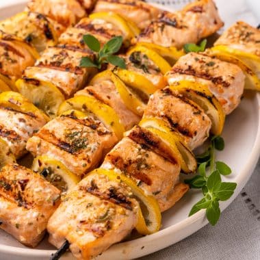lemon herb grilled salmon kebabs stacked on a white plate