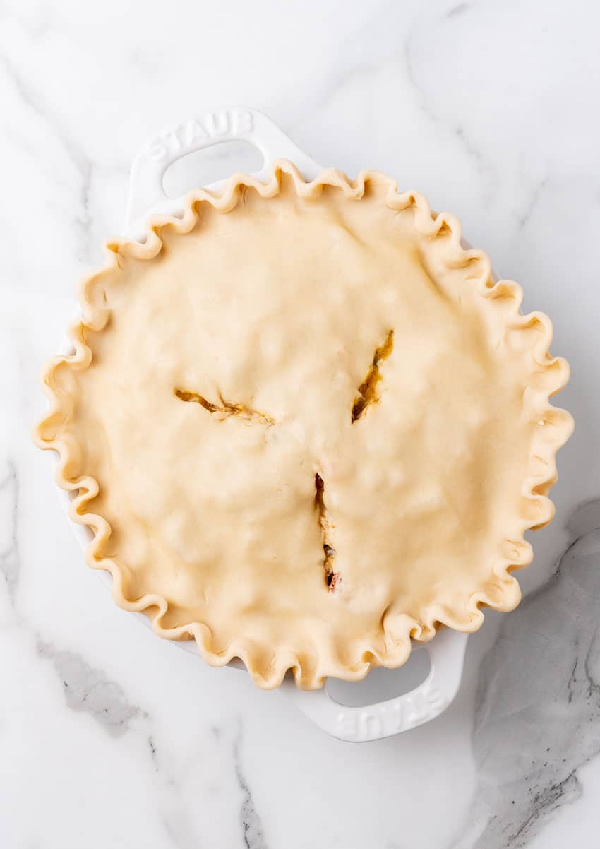 an unbaked cajun pot pie in a white pie plate