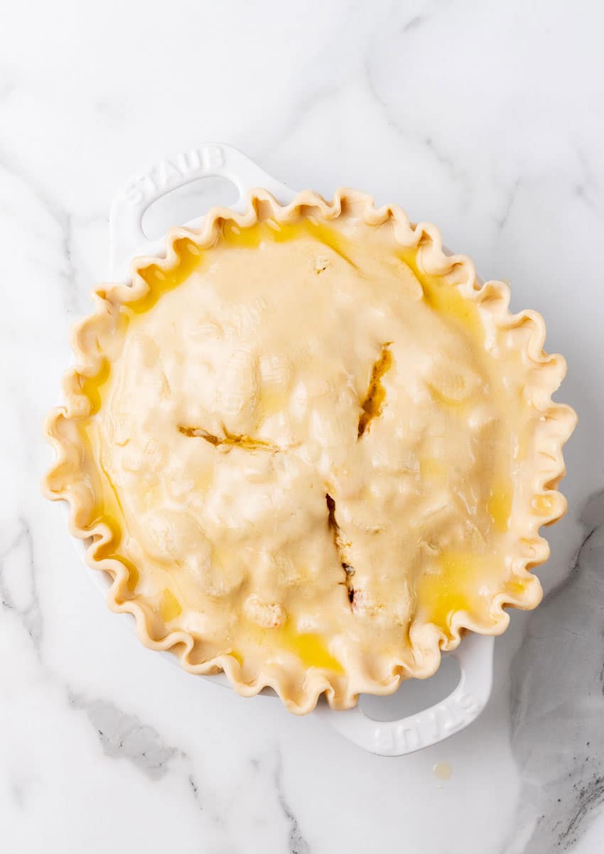 an unbaked cajun pot pie in a white pie plate