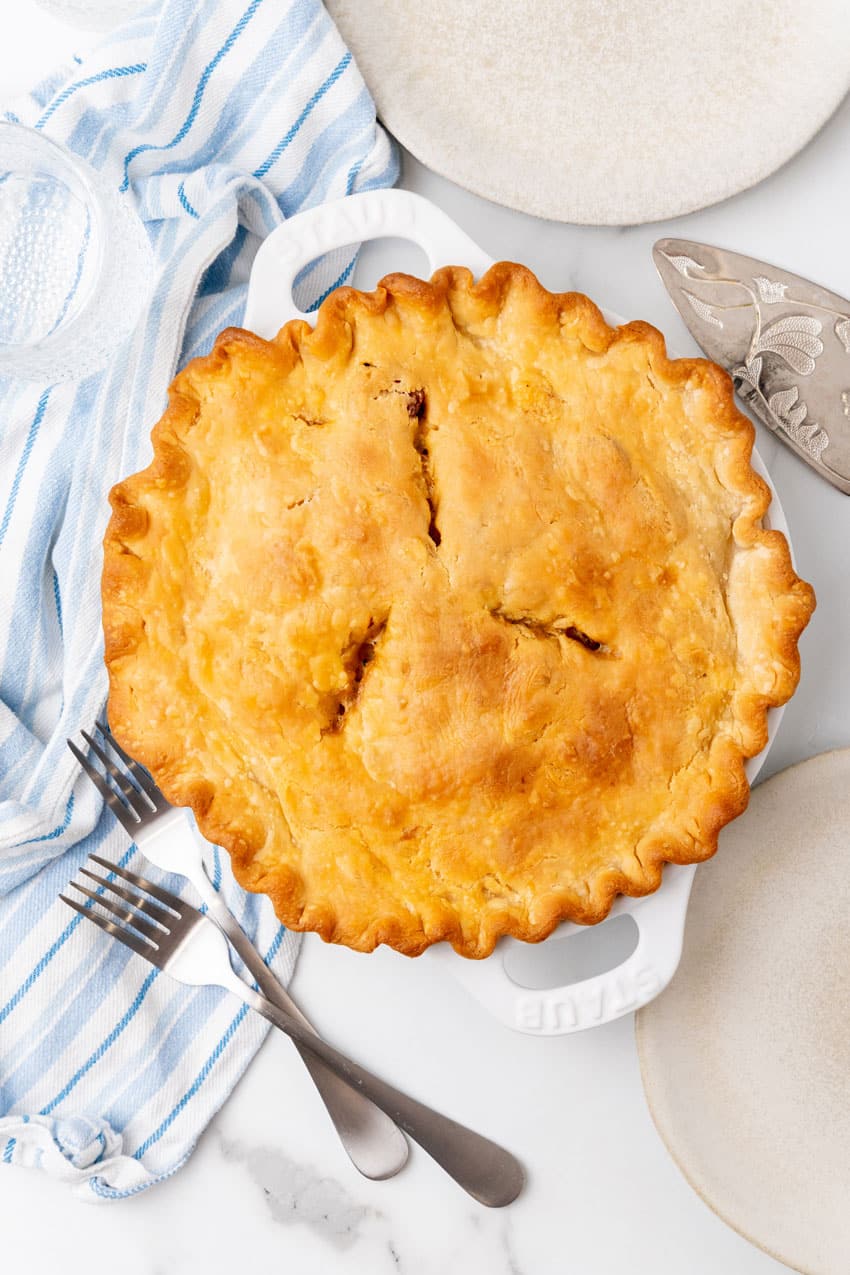 a baked creole pot pie in a white pie plate