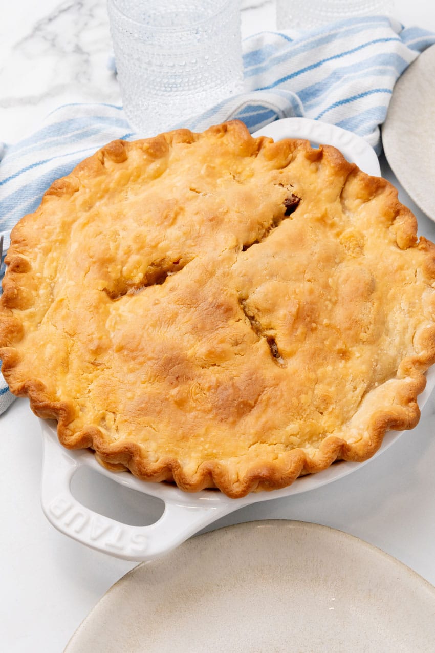 a baked creole pot pie in a white pie plate