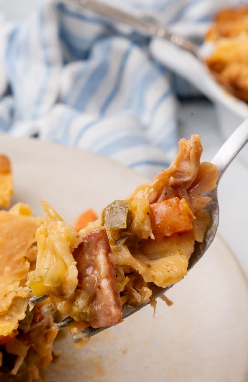 a silver fork holding up a scoop of smoked sausage and chicken pot pie