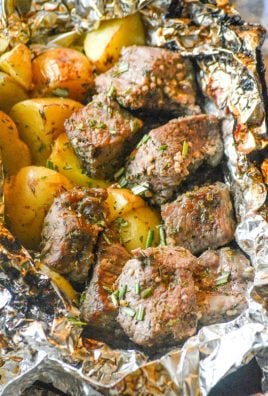 garlic butter steak and potato foil packet opened and sprinkled with parsley