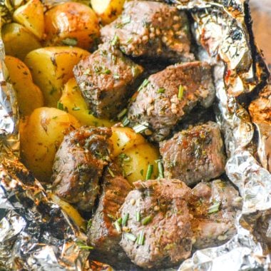 garlic butter steak and potato foil packet opened and sprinkled with parsley