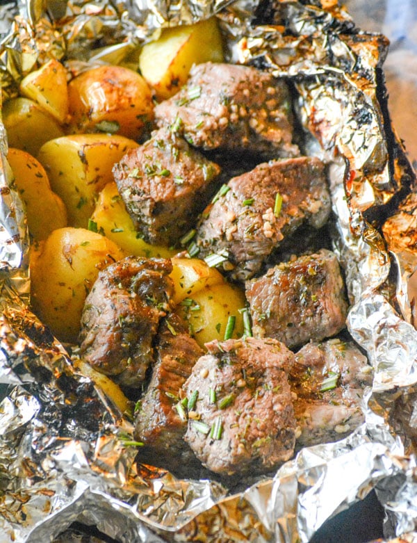 garlic butter steak and potato foil packet opened and sprinkled with parsley