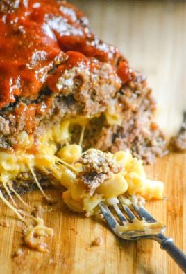a fork holding some of the macaroni and cheese center from a honey barbecue flavored stuffed meatloaf