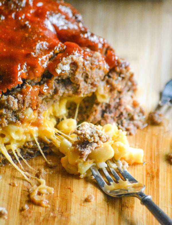 a fork holding some of the macaroni and cheese center from a honey barbecue flavored stuffed meatloaf