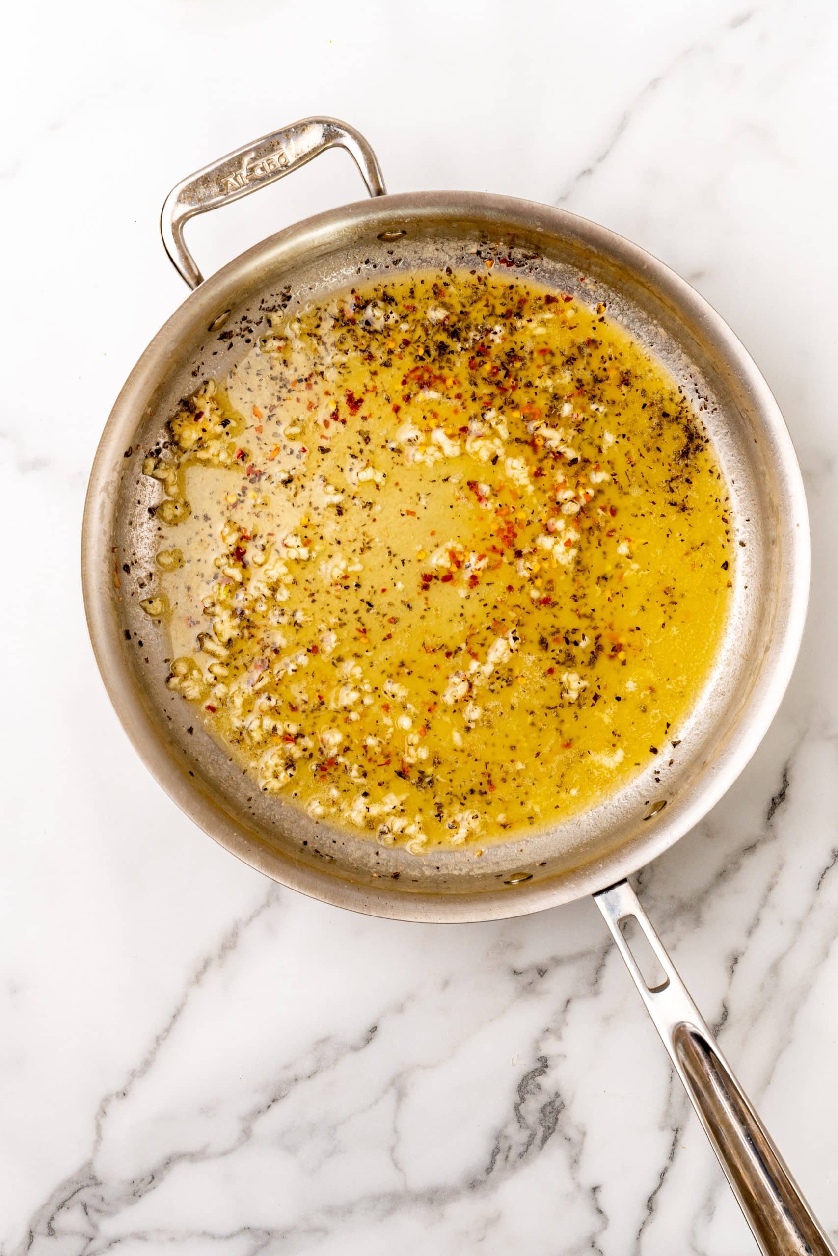 seasoned garlic butter sauce in a large silver skillet